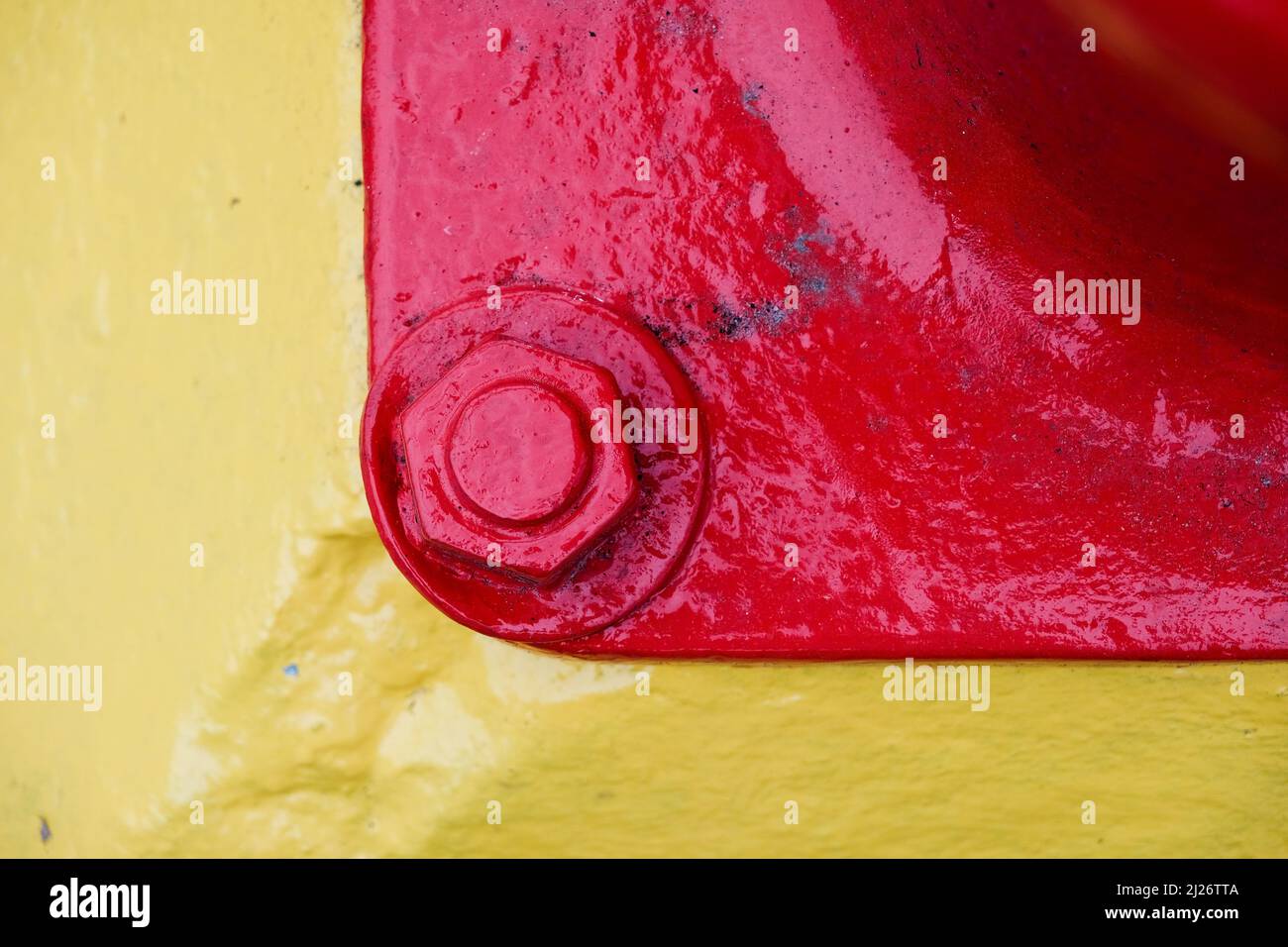 Rote und gelbe paimted Stahlmutter und Schraube Stockfoto