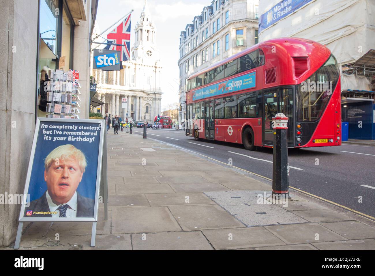 Ein Doppeldeckerbus fährt an einem Schild mit dem britischen Premierminister Boris Johnson vorbei, das vor einem Grusskarten-Laden im Zentrum von London zu sehen ist. Stockfoto