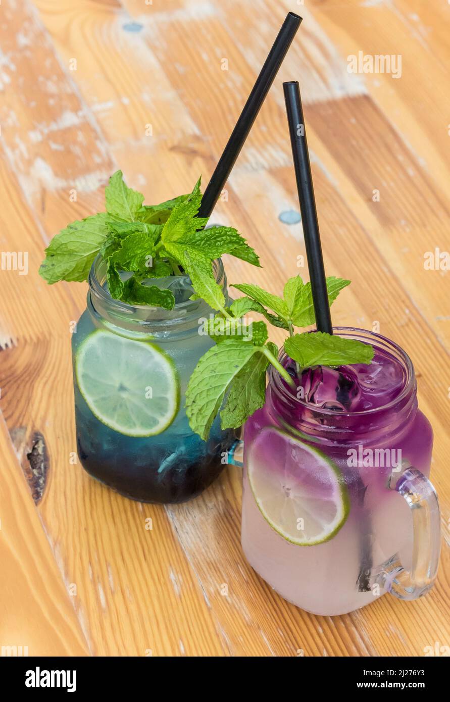 Farbenfrohe, violette und blaue Cocktailgetränke mit frischer Minze Stockfoto