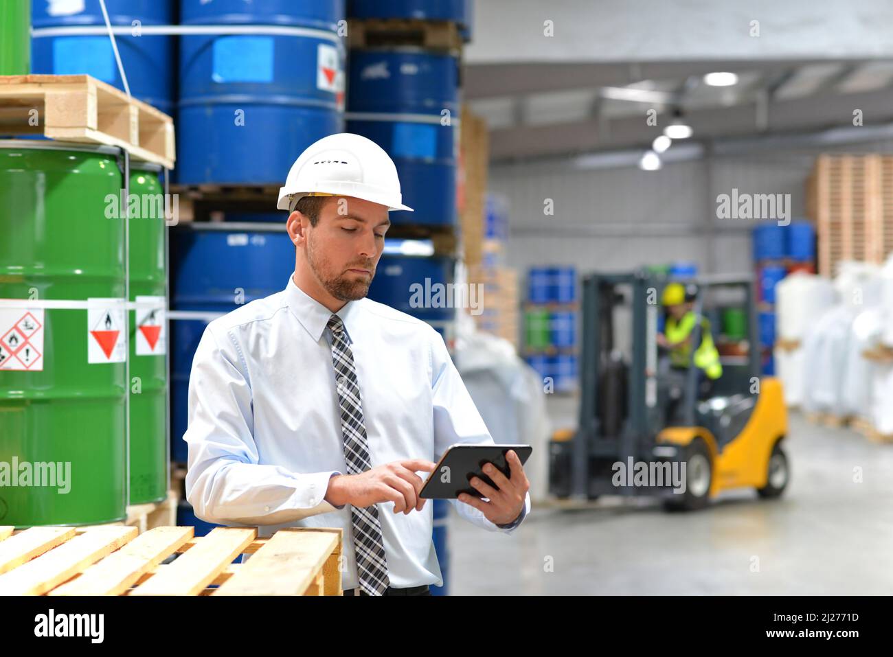 Manager in einem Logistikunternehmen Arbeiten in ein Lager mit Chemikalien - Kontrolle der Waren mit Tablet Stockfoto