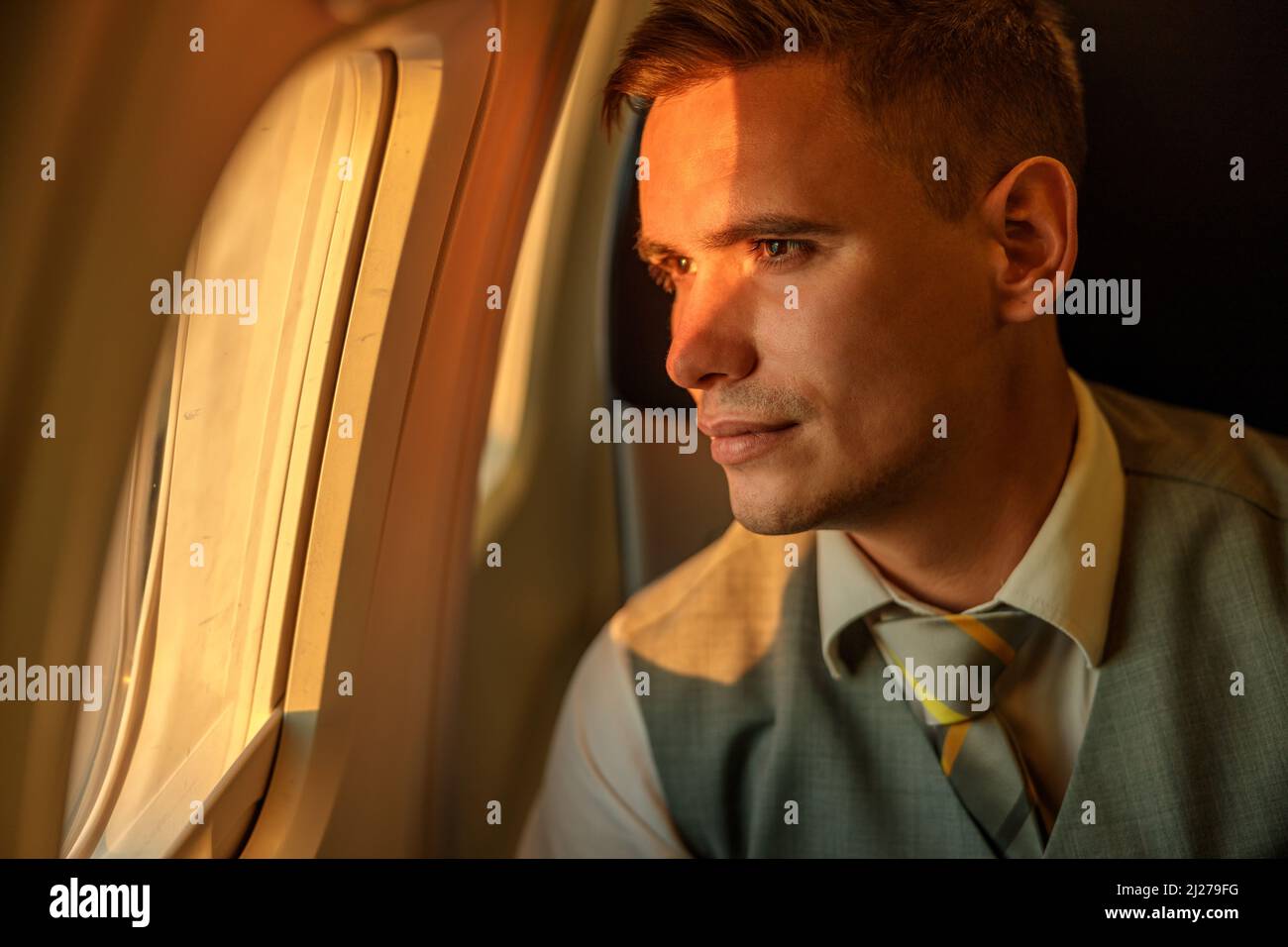 Mann, der im Flugzeug aus dem Fenster schaute Stockfoto