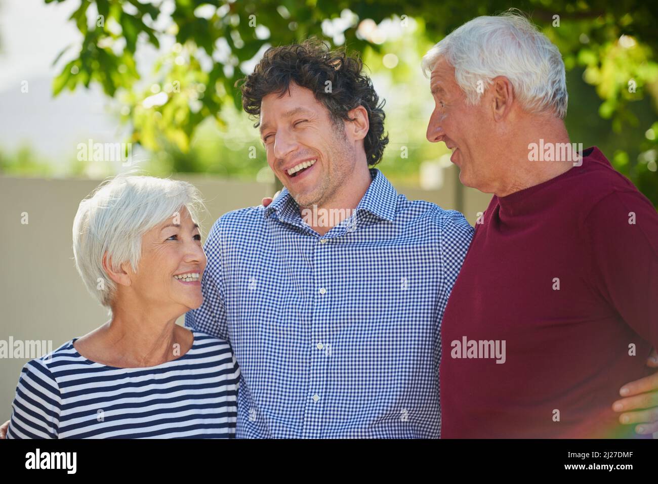 Sie hätten nicht stolzer sein können. Ausgeschnittene Aufnahme eines älteren Paares, das mit ihrem Sohn draußen stand. Stockfoto