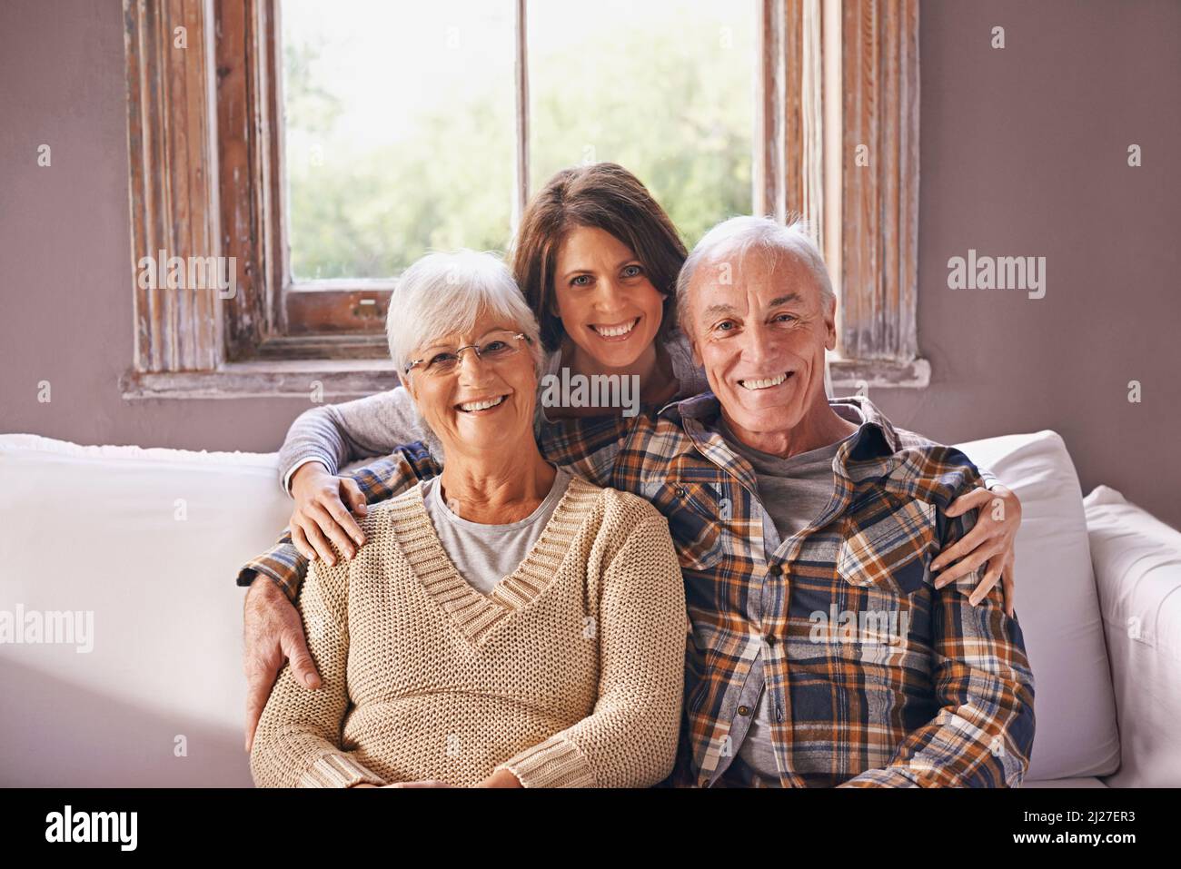 Ich liebe meine Eltern. Ein beschnittenes Porträt eines glücklichen älteren Ehepaares und ihrer erwachsenen Tochter zu Hause. Stockfoto