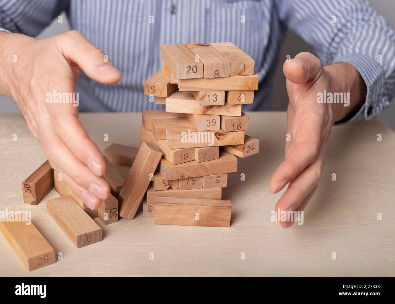 Krisenkonzept mit herunterfallenden Holzblöcken. Hochwertige Fotos Stockfoto