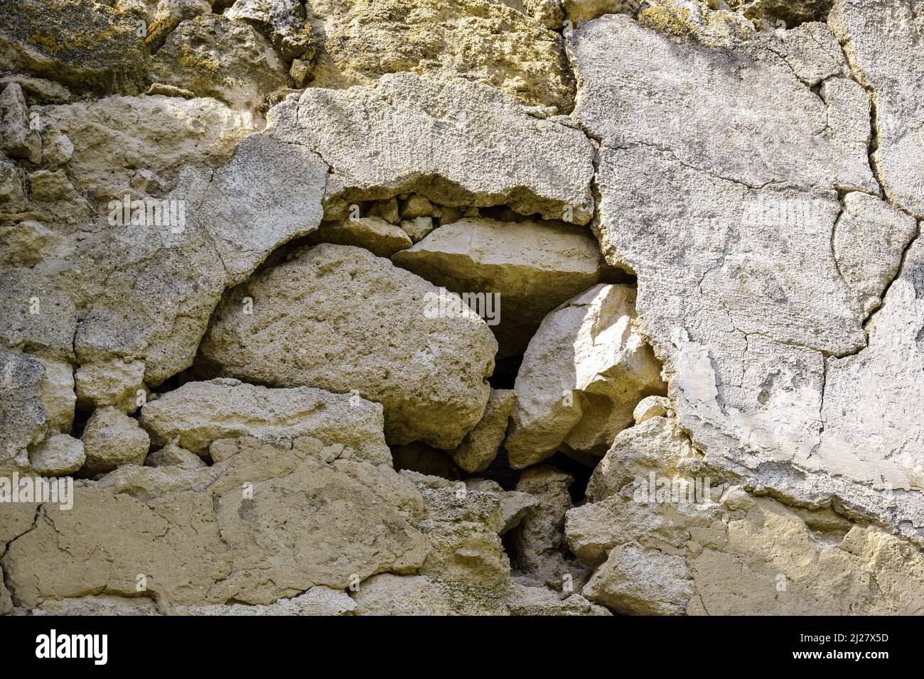 Alte verfallene Steinmauer mit Putzresten. Uralte Ruinen. Nahaufnahme. Selektiver Fokus. Stockfoto Alte verfallene Steinmauer mit Putzresten. Uralte Ruinen. Nahaufnahme. Selektiver Fokus. Stockfoto
