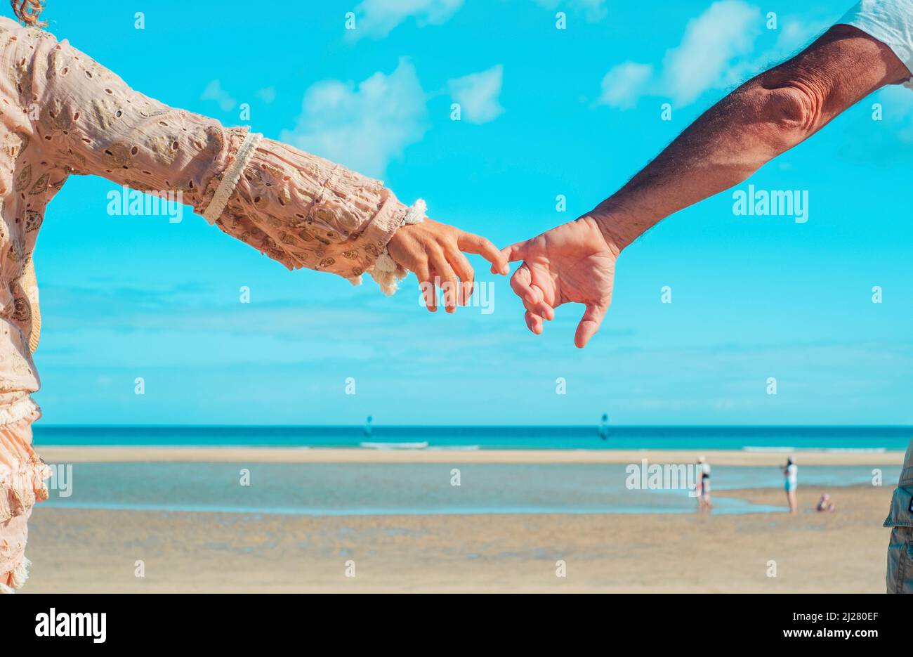 Rückansicht von Mann und Frau Hand in Hand vor einem tropischen Strand. Liebe und Beziehung Paar Menschen halten die Hände und genießen Freizeit Stockfoto