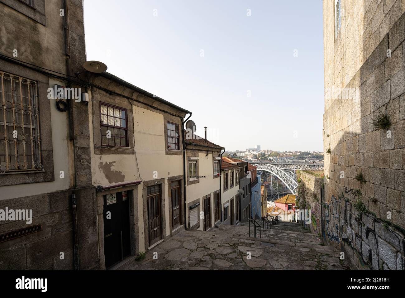 Porto, Portugal. 2022. März. Eine typische Straße zwischen den alten Häusern der Innenstadt, die mit der Eisenbride Dom Luís i zum Fluss hinunter geht Stockfoto