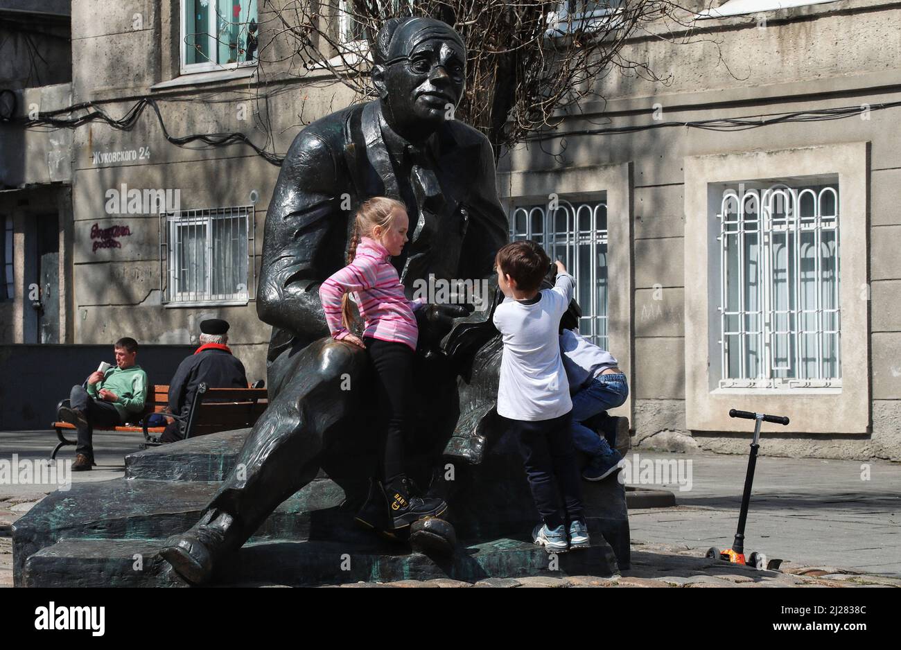 ODESA, UKRAINE - 30. MÄRZ 2022 - zwei Mädchen erkunden das Denkmal des in Odesa geborenen Schriftstellers, Journalisten, Dramatikers und Literaturübersetzers Isaac Babel nea Stockfoto