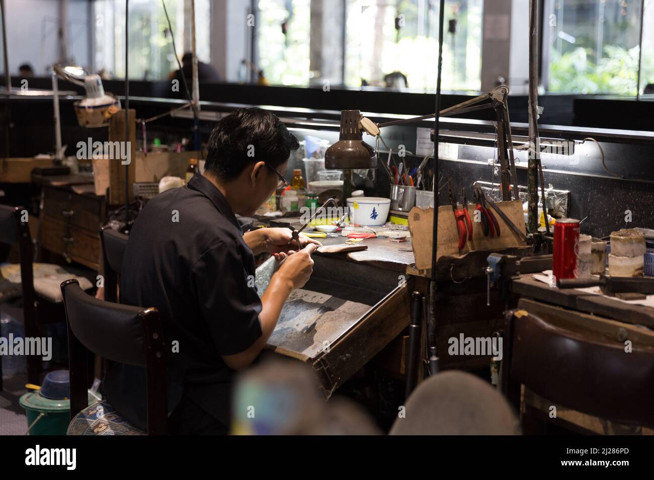 Thailändischer Juwelier, der in einer Werkstatt feinen Schmuck herstellt Stockfoto