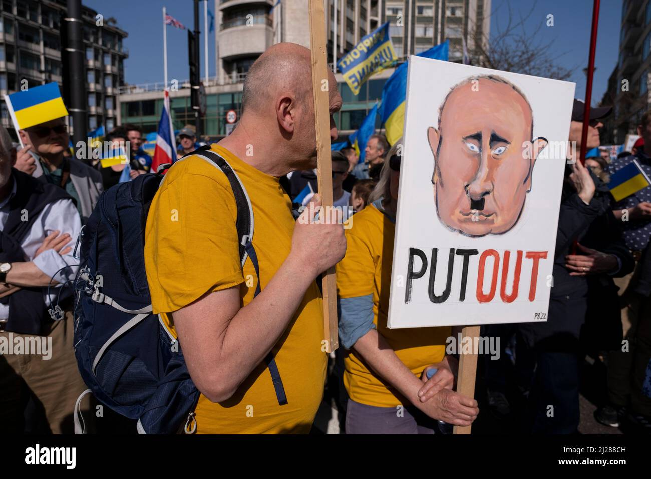 Bild des russischen Präsidenten Wladimir Putin, beschrieben als eine Hitlerfigur, als sich Tausende von Menschen in der Hauptstadt zu einem friedensmarsch ‘London steht mit der Ukraine’ in Solidarität mit dem Volk der Ukraine am 26.. März 2022 in London, Großbritannien, versammeln. Der Konflikt in der Ukraine befindet sich nun in seinem zweiten Monat, und ihr Präsident hat die Menschen auf der ganzen Welt dazu aufgerufen, sich gegen die russische Invasion und den anhaltenden Krieg in der Region zu vereinen. Die ukrainische Flagge in Gelb und Blau war überall in dieser bunten Show der Einheit zu sehen. Stockfoto