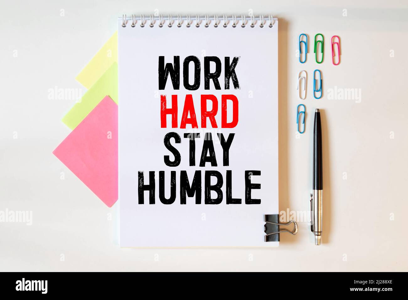 Inspirierende und Motivation Leben Zitat auf dem Notizblock - Arbeit hart bleiben bescheiden Stockfoto
