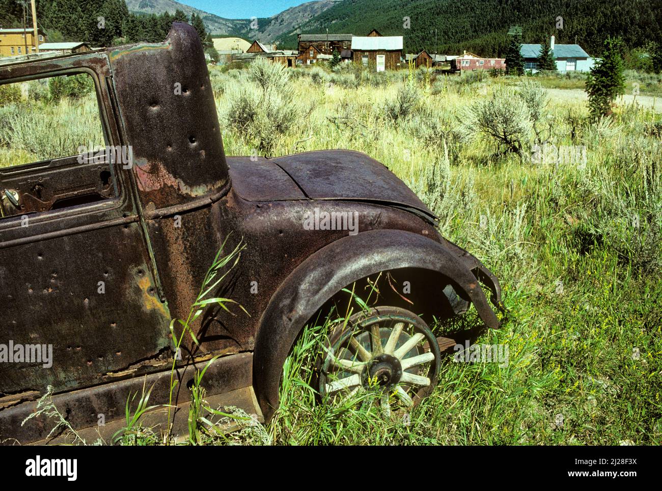 MT: Jefferson County, Boulder Valley, Elkhorn. Geisterstadt in einem Canyon, über einem verlassenen antiken Auto mit Holzspulen gesehen] Stockfoto