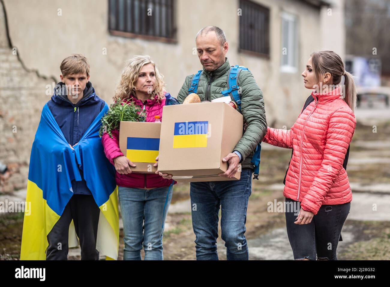 Die ukrainische Familie akzeptiert Kisten mit humanitärer Hilfe, nachdem Russland die Ukraine angegriffen und die Krise ausgelöst hat. Stockfoto