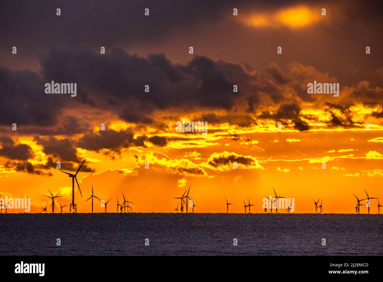 Walney Island, Cumbrian Coast. 30.. März 2022. Wetter in Großbritannien. Nach einem Tag mit Regen, grauem Himmel und einer kalten Nordbrise. Sonnenuntergang von der Cumbrian Coast, Blick über die Irische See zur entfernten Walney Offshore Windfarm. Kredit:greenburn/Alamy Live Nachrichten. Stockfoto