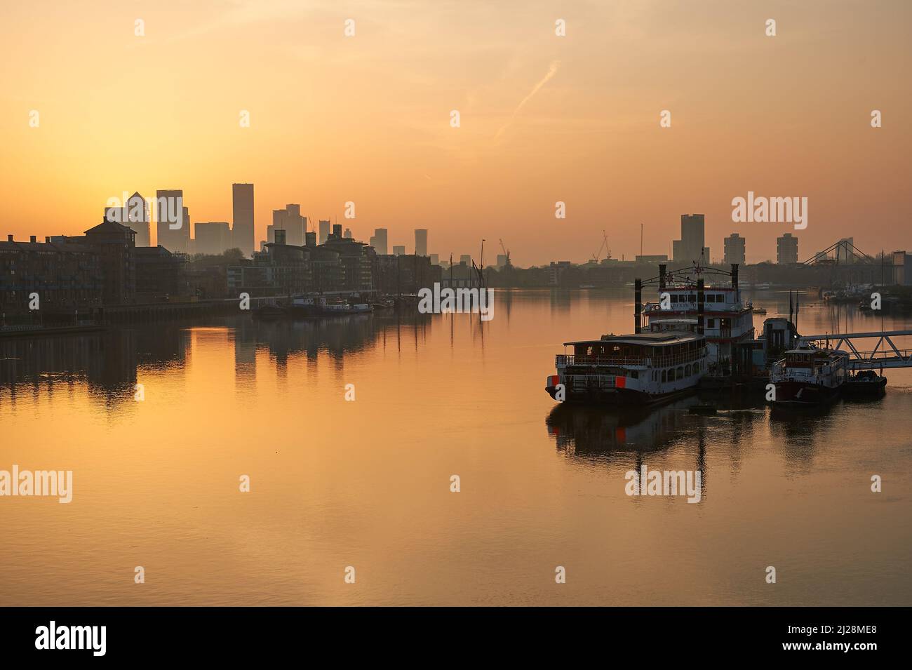 Goldener Sonnenaufgang über der Themse und mit Canary Wharf an der Skyline, London England Stockfoto