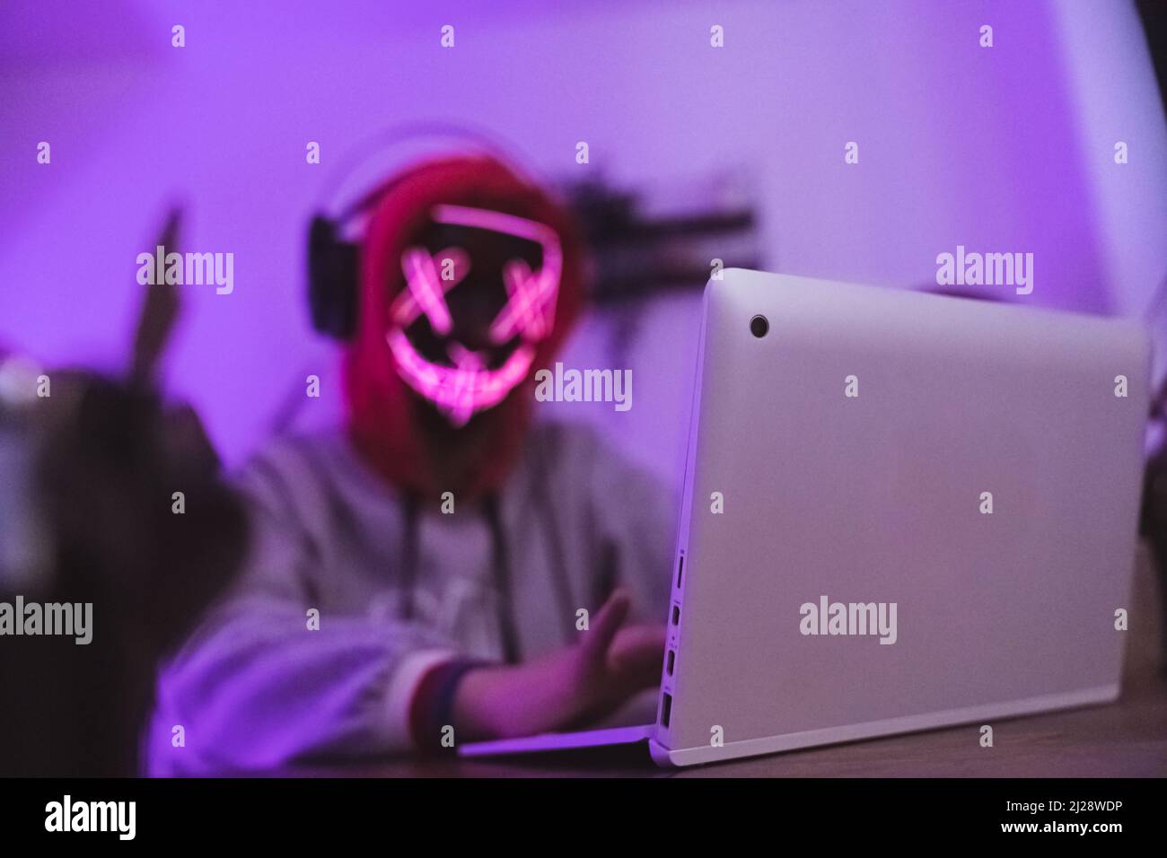 Gefährlicher maskierter Hacker mit Laptop. Internet-Sicherheitskonzept. Hochwertige Fotos Stockfoto