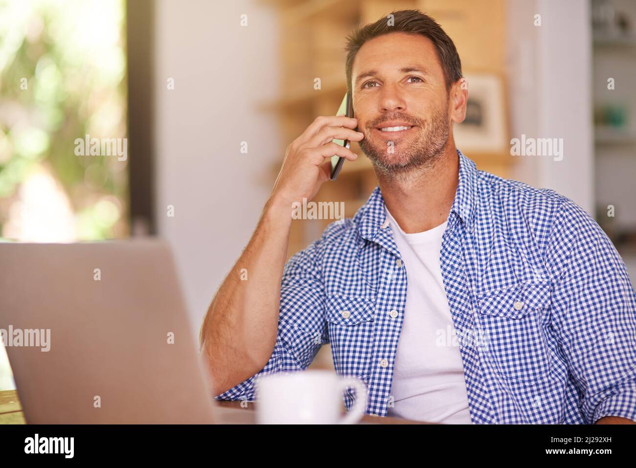 Clients von zu Hause aus anrufen. Aufnahme eines jungen Mannes, der von zu Hause aus arbeitet. Stockfoto