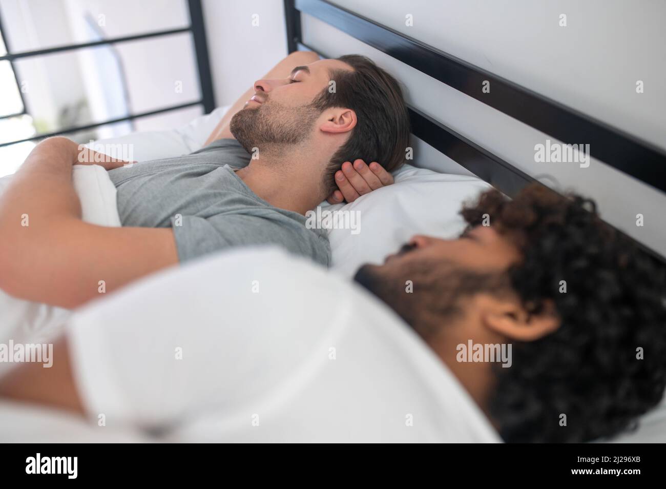 Zwei schwule Männer dösen in ihrem Schlafzimmer Stockfoto