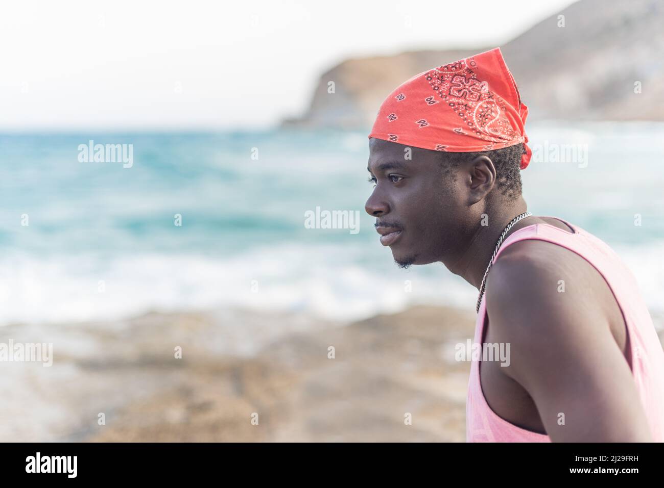Schwarzer Mann, der das Meer betrachtet und das gute Wetter genießt Stockfoto