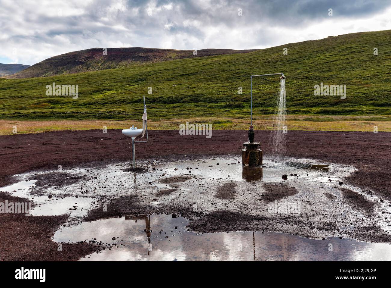 Heiße Außendusche ohne Abfluss und Waschbecken mit Handtuch, Kiesplatz in der Nähe des Vulkans Krafla, Myvatn, Nordisland, Island Stockfoto