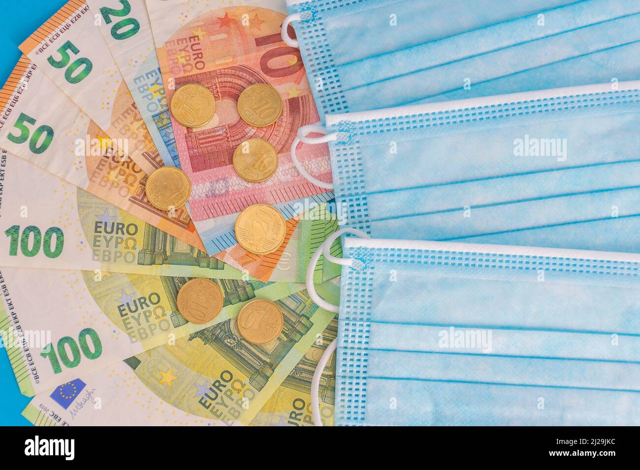 Medizinische Masken und Euro-Banknoten. Finanzkrise aufgrund von Coronavirus-Verlusten, selektiver Fokus Stockfoto