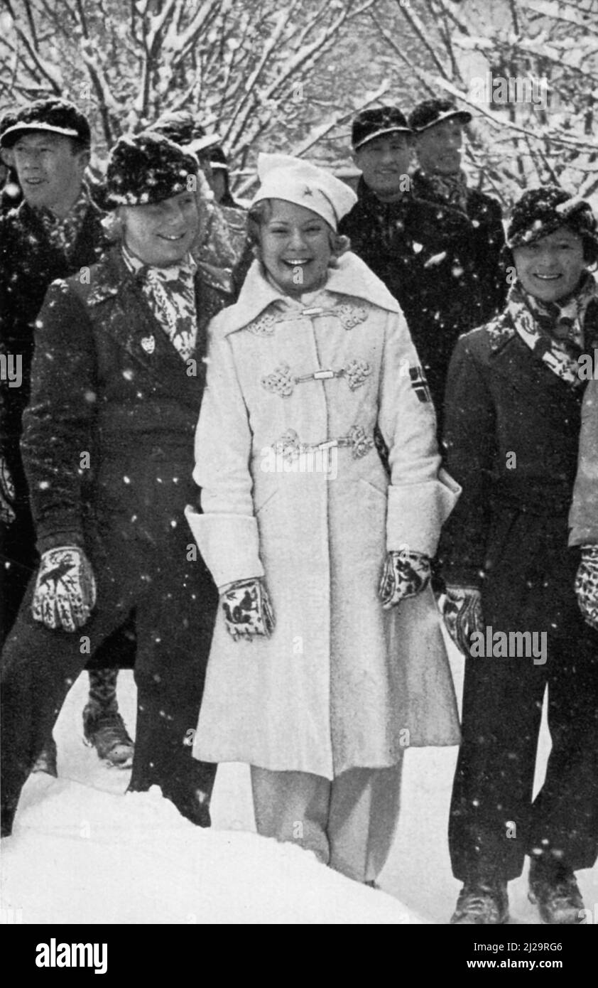 Sonja Henie, und Goldmedaillengewinnerin, wartet in der Schneehülle vor dem Stadion, die sie kurz darauf mit ihren Kameraden, der Eiskunstläuferin, betreten wird Stockfoto