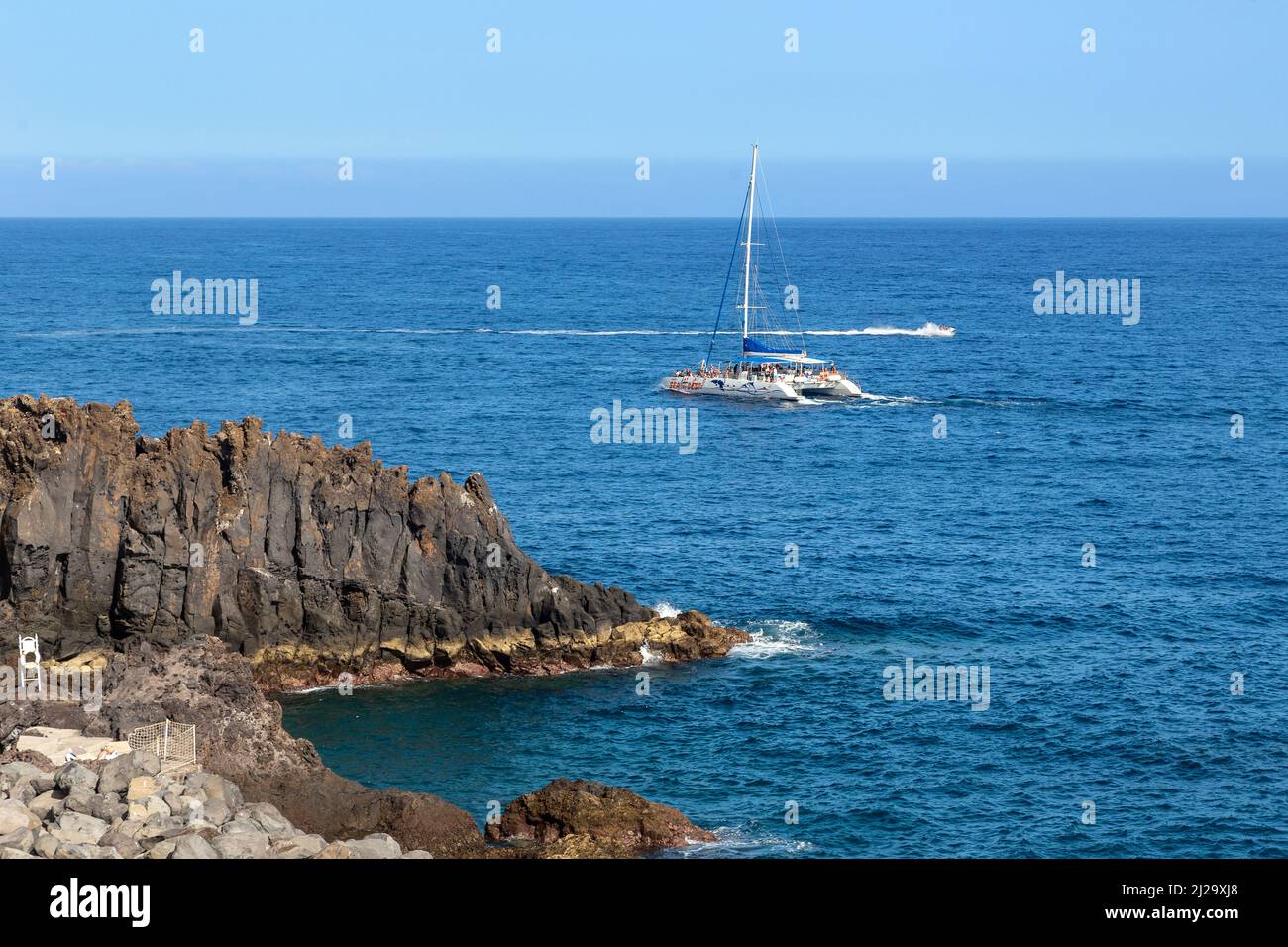 MADEIRA, PORTUGAL - 19. AUGUST 2021: Dies ist ein Vergnügungskatamaran vor den felsigen Küsten der Insel. Stockfoto MADEIRA, PORTUGAL - 19. AUGUST 2021: Dies ist ein Vergnügungskatamaran vor den felsigen Küsten der Insel. Stockfoto
