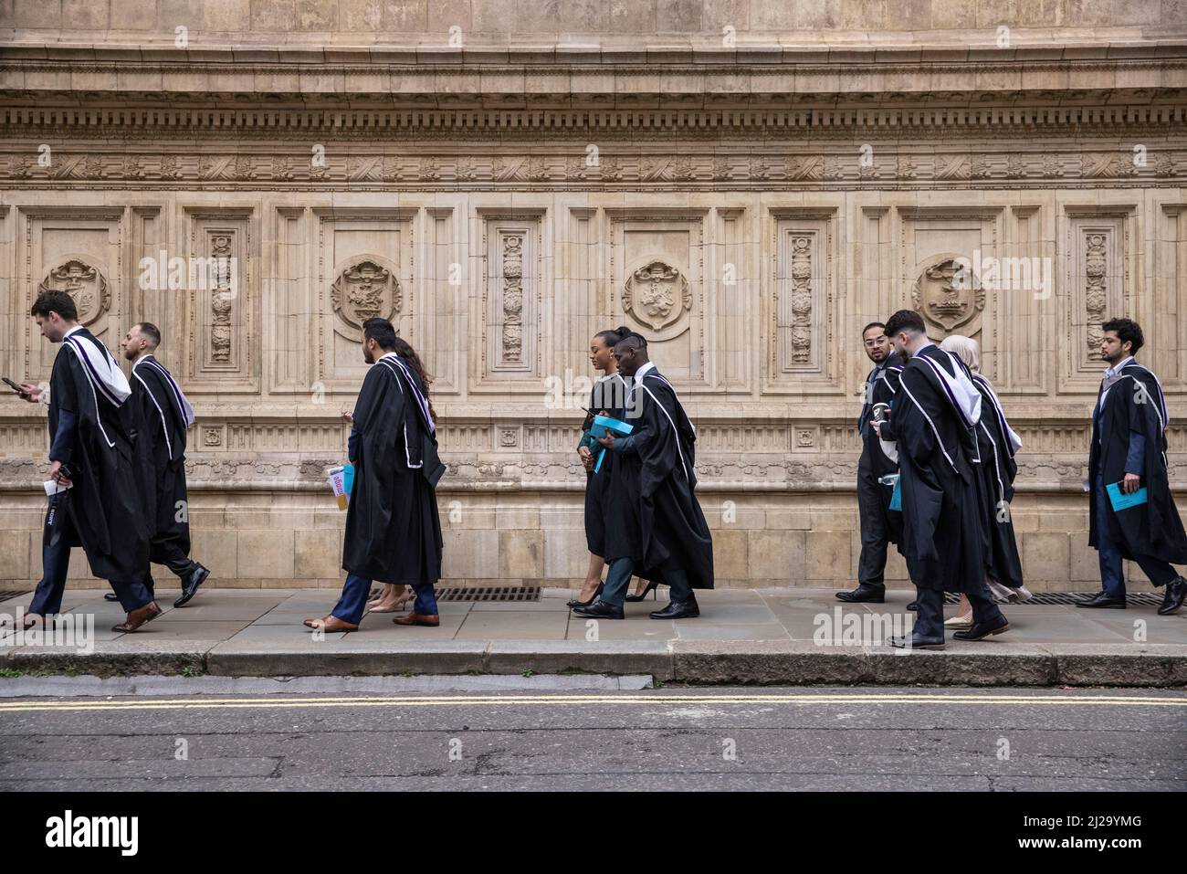 Absolventen des Imperial College London genießen die Atmosphäre außerhalb der Royal Albert Hall, obwohl Eltern oder Familienmitglieder nicht teilnehmen durften. Stockfoto
