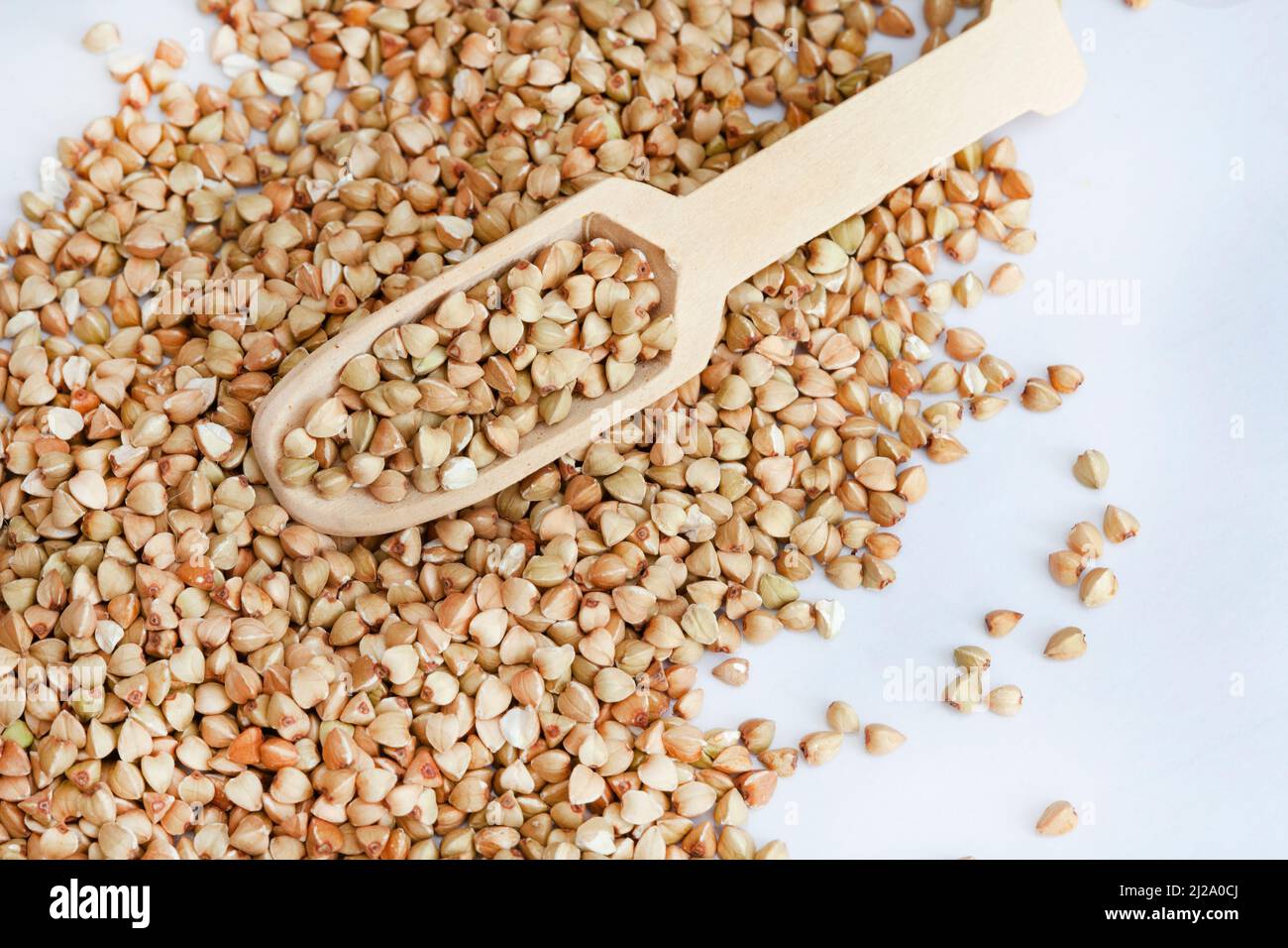 Buchweizen auf heller Oberfläche mit Holzlöffel und Kopierraum Stockfoto