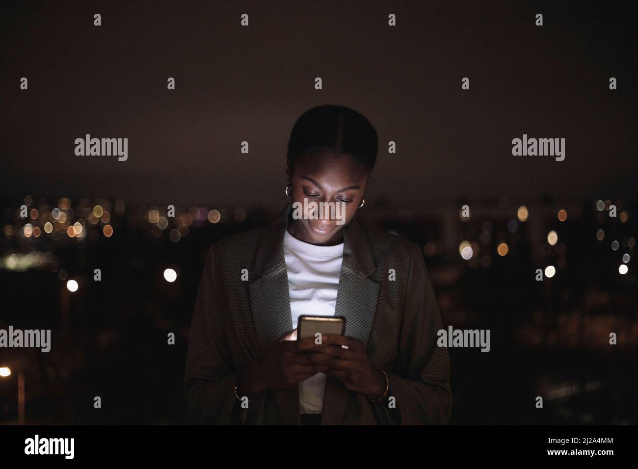 Geschäftsfrau Textnachrichten auf Smartphone in der Nacht Stockfoto