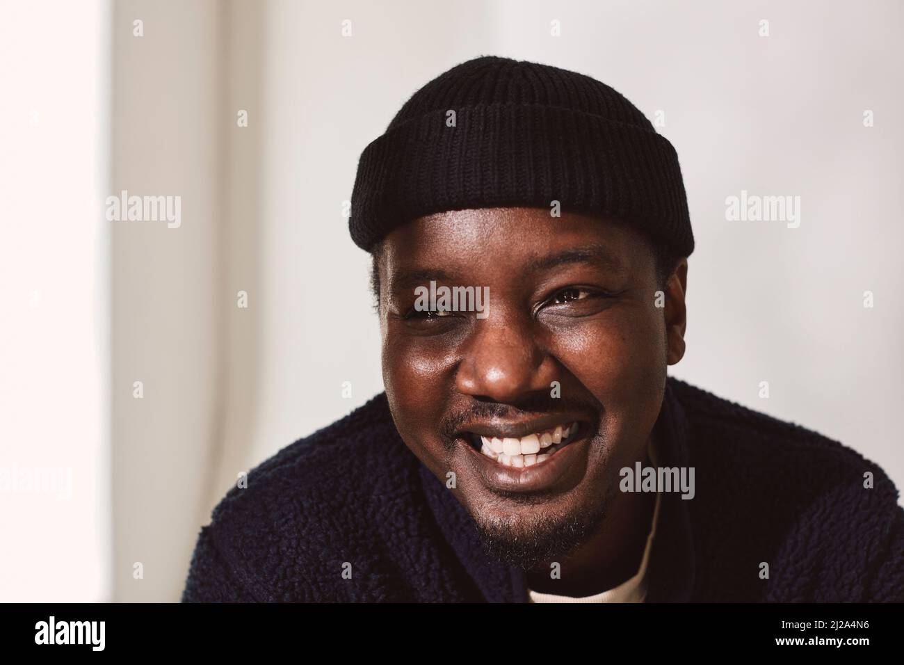 Glücklicher Mann mit mittlerem Erwachsenenalter, der gegen die Wand schaut Stockfoto Glücklicher Mann mit mittlerem Erwachsenenalter, der gegen die Wand schaut Stockfoto