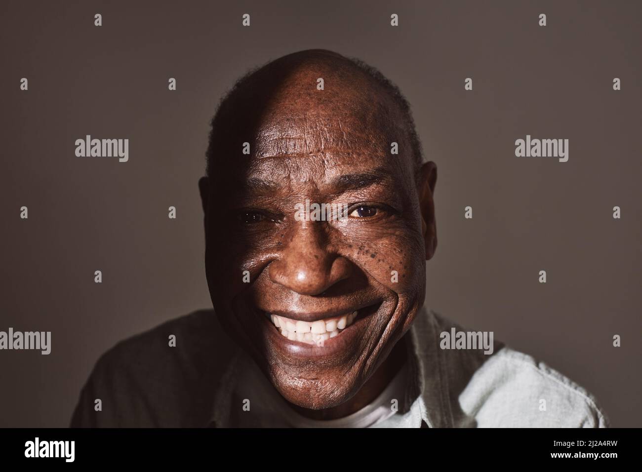 Porträt eines lächelnden älteren Mannes vor weißem Hintergrund Stockfoto