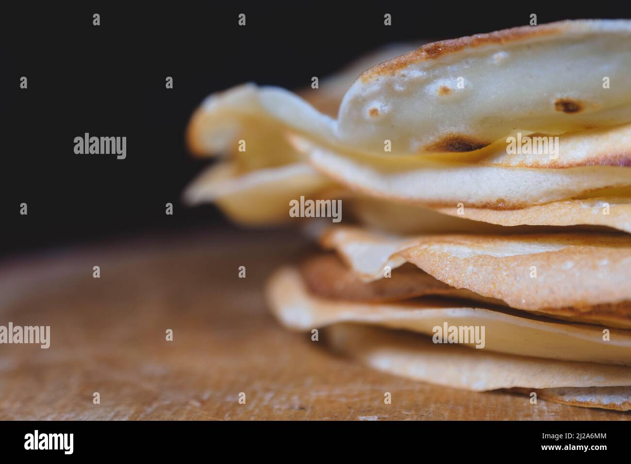 Nahaufnahme von gestapelten frisch gebackenen Pfannkuchen auf einem Holzbrett Stockfoto