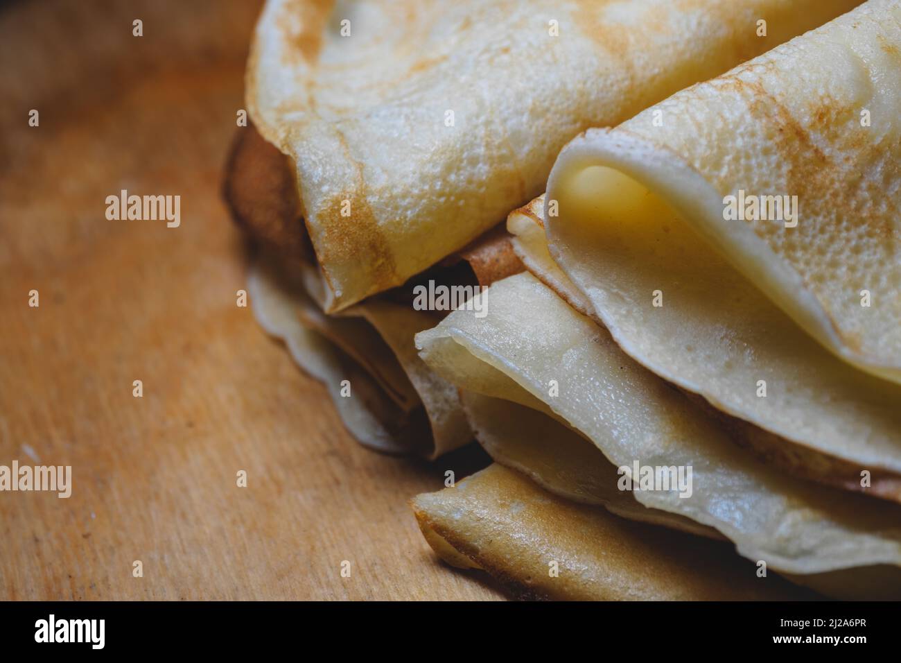 Nahaufnahme von gestapelten frisch gebackenen Pfannkuchen auf einem Holzbrett Stockfoto