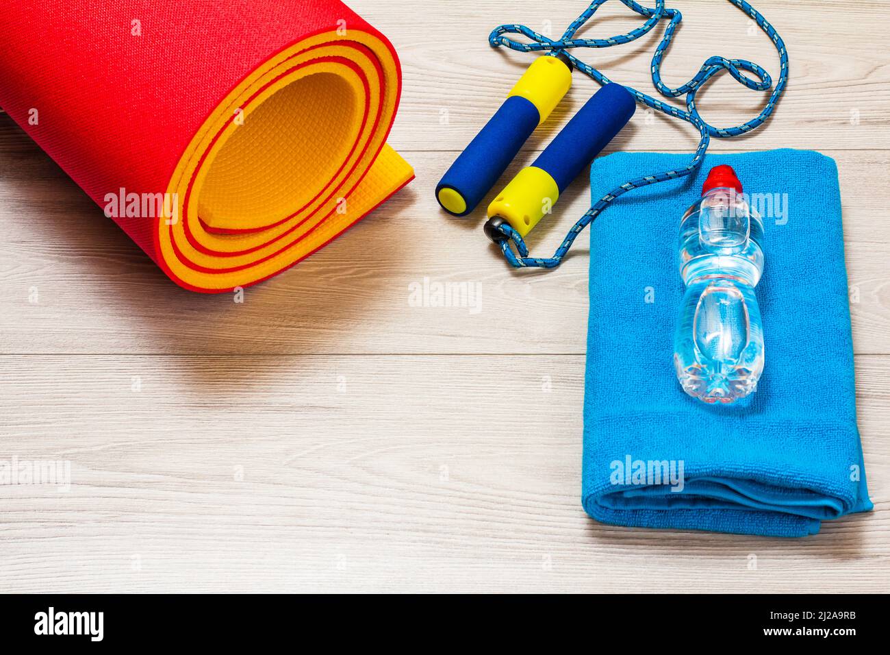 Yogamatte und Überspringen von Rop für Fitness, ein Handtuch, eine Flasche Wasser in einem Raum oder ein Fitnessstudio auf dem grauen Boden. Stockfoto