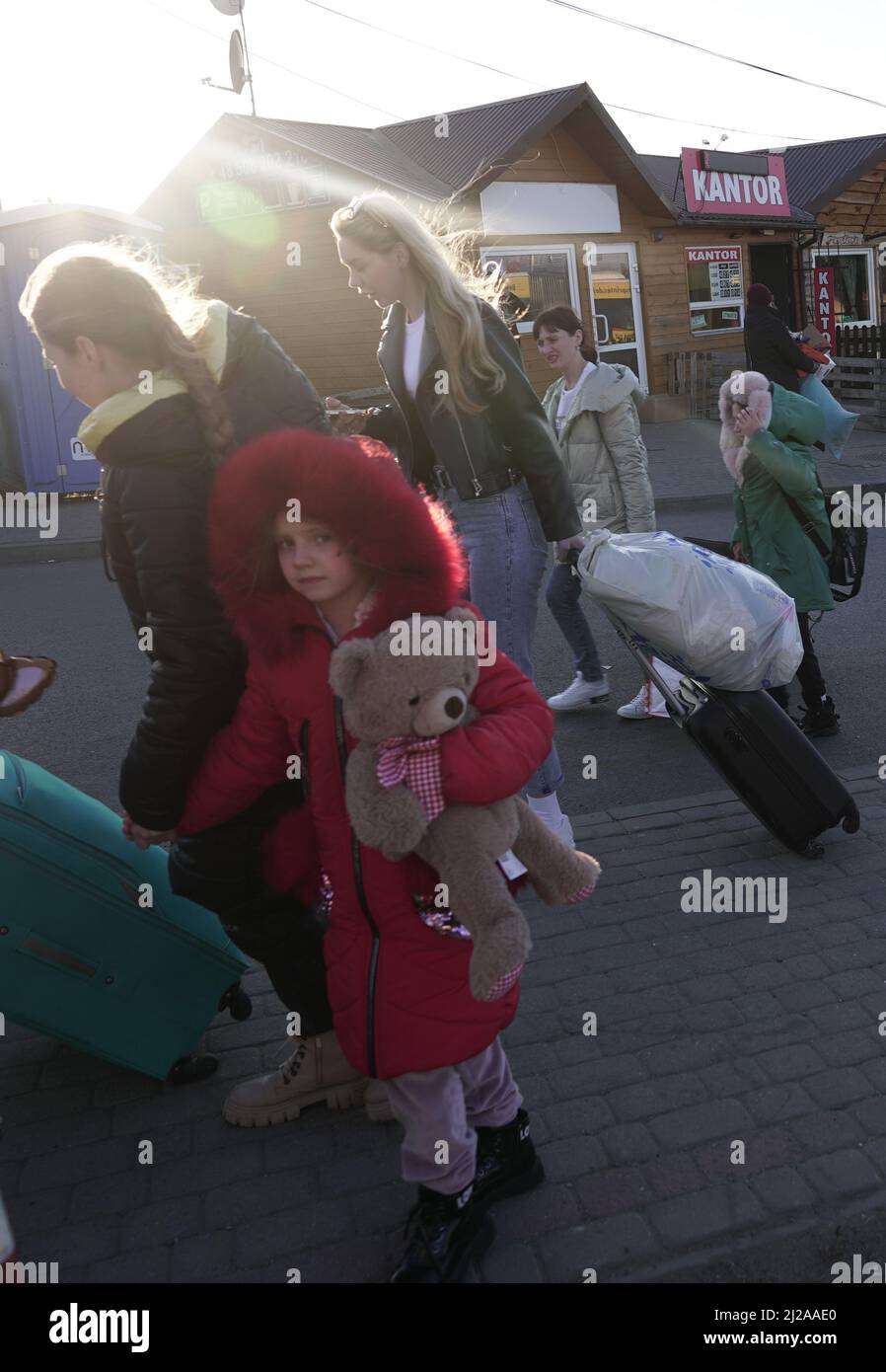 MEDYKA, POLEN - 28. MÄRZ 2022 - Ein Mädchen trägt einen Teddybär, als ukrainische Flüchtlinge, die vor der russischen Invasion fliehen, ihre Koffer vor dem Medyka-Sh ziehen Stockfoto