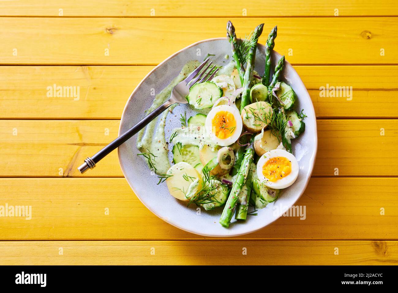 Von oben appetitlichen Frühlingssalat mit Spargel und Eiern und Kartoffeln zum Mittagessen auf Holztisch serviert Stockfoto