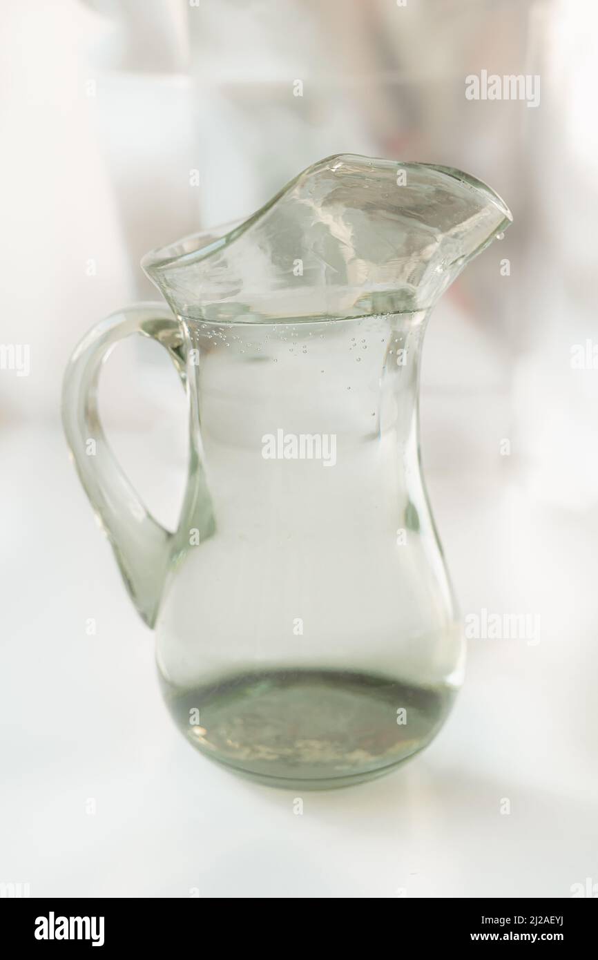 Sauberes Wasser im Glaskrug, Quellwasser in Rohrleitungen, Betrieb von Wasserfiltern Stockfoto