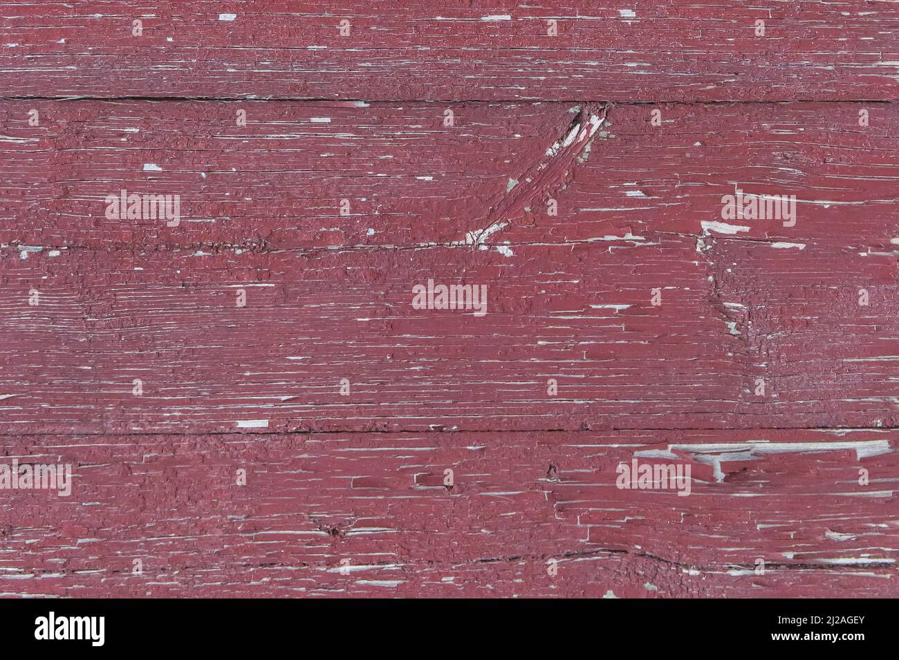Alte hölzerne abgenutzte Zaunbretter verwitterte Textur in abblätternder roter Farbe schmutzig veralteter Hintergrund. Stockfoto