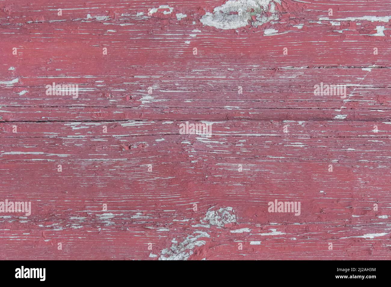 Alte hölzerne abgenutzte Zaunbretter verwitterte Textur in abblätternder roter Farbe schmutzig veralteter Hintergrund. Stockfoto