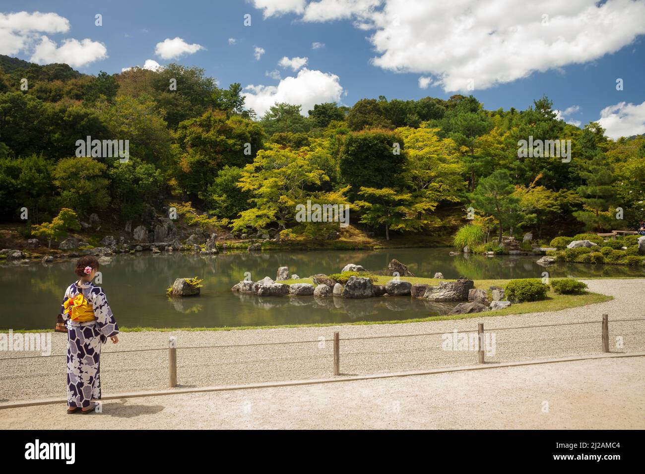 Die junge Frau, mit dem Rücken zugewandt, trägt eine traditionelle Yukata im japanischen Zen-Garten des buddhistischen Tempels Tenryu-Ji, Arashiyama, Kyoto Stockfoto