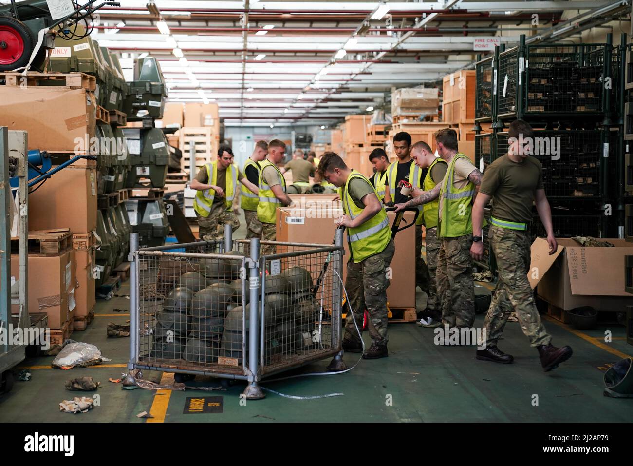 Mitglieder des Militärs packen Tausende von überschüssigen Helmen, die von der Armee für „Hats off to Ukraine“ im MOD Donnington in Shropshire gespendet wurden. Dreißig Mitglieder des in den Midlands ansässigen 'Poachers', vom 2. Bataillon des Royal Anglian Regiments, haben in nur zwei Wochen 84.000 überschüssige Helme sortiert und verpackt, die für das ukrainische Militär gebunden sind, und befinden sich nun im letzten Anstoß, alle Helme bis Freitag zu verpacken. Bilddatum: Donnerstag, 31. März 2022. Stockfoto