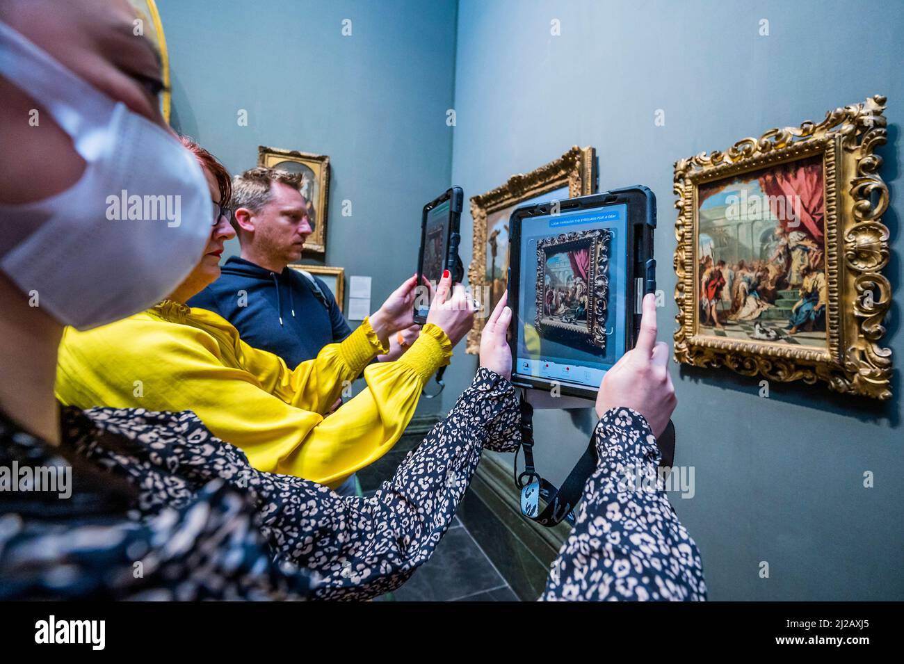 London, Großbritannien. 31. März 2022. Die Mitarbeiter der Galerie testen das System, indem sie mit Hilfe von animierten „Keepers“ – dem „Keeper of Paintings“ und der „Palette of Perception“-Familienspur-App in der National Gallery – nach Informationen suchen und Juwelen sammeln, während sie ihre erste immersive Augmented Reality-App startet, die mit Hilfe von Over erstellt wurde 70 Kinder rechtzeitig zu den Osterferien. Es handelt sich um eine kostenlose mobile Erfahrung, die AR-Technologie nutzt und Kinder dazu ermutigt, die Galerie zu erkunden und mehr über ihre Gemälde zu erfahren. Kredit: Guy Bell/Alamy Live Nachrichten Stockfoto