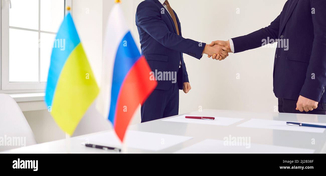 Russische und ukrainische Diplomaten verhandeln über ein friedliches Abkommen und tauschen Handschakes aus Stockfoto