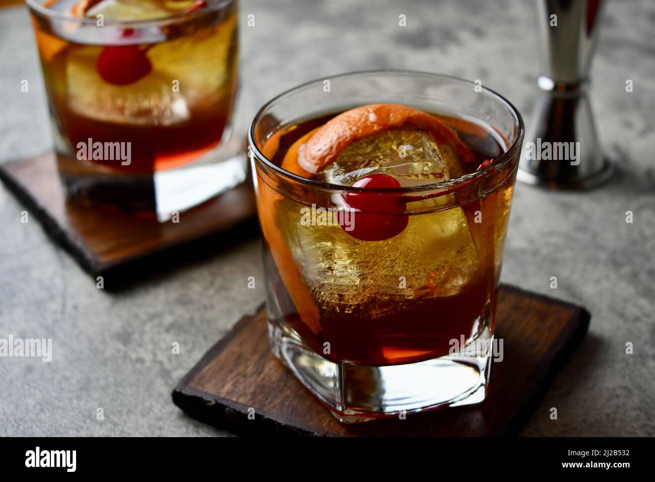 Altmodischer Cocktail mit Orangenschalen-Garnitur und Maraschino-Kirsche Stockfoto