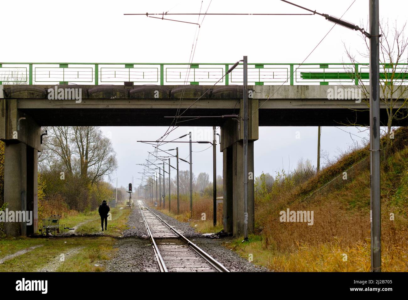 Flüchtlinge und Migranten in der Region Hauts-de-France (Nordfrankreich), am 26. November 2021: Mann, der in Loon-Plage Les Kemp entlang der Eisenbahnlinie geht Stockfoto