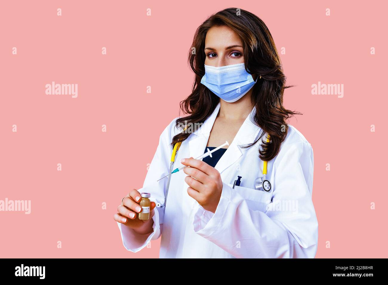 Schöne Ärztin in medizinischer Maske mit Covid-19-Impfstoff und Spritze in den Händen Arzt Stockfoto