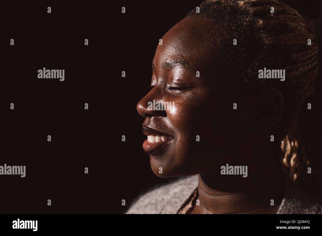 Lächelnde Frau mit geschlossenen Augen Tag träumen im Studio Stockfoto