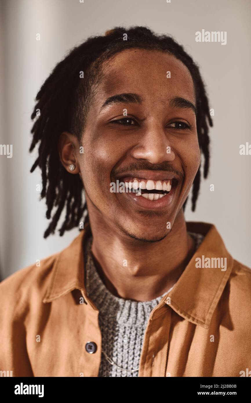 Glücklicher junger Mann, der im Studio wegschaut Stockfoto