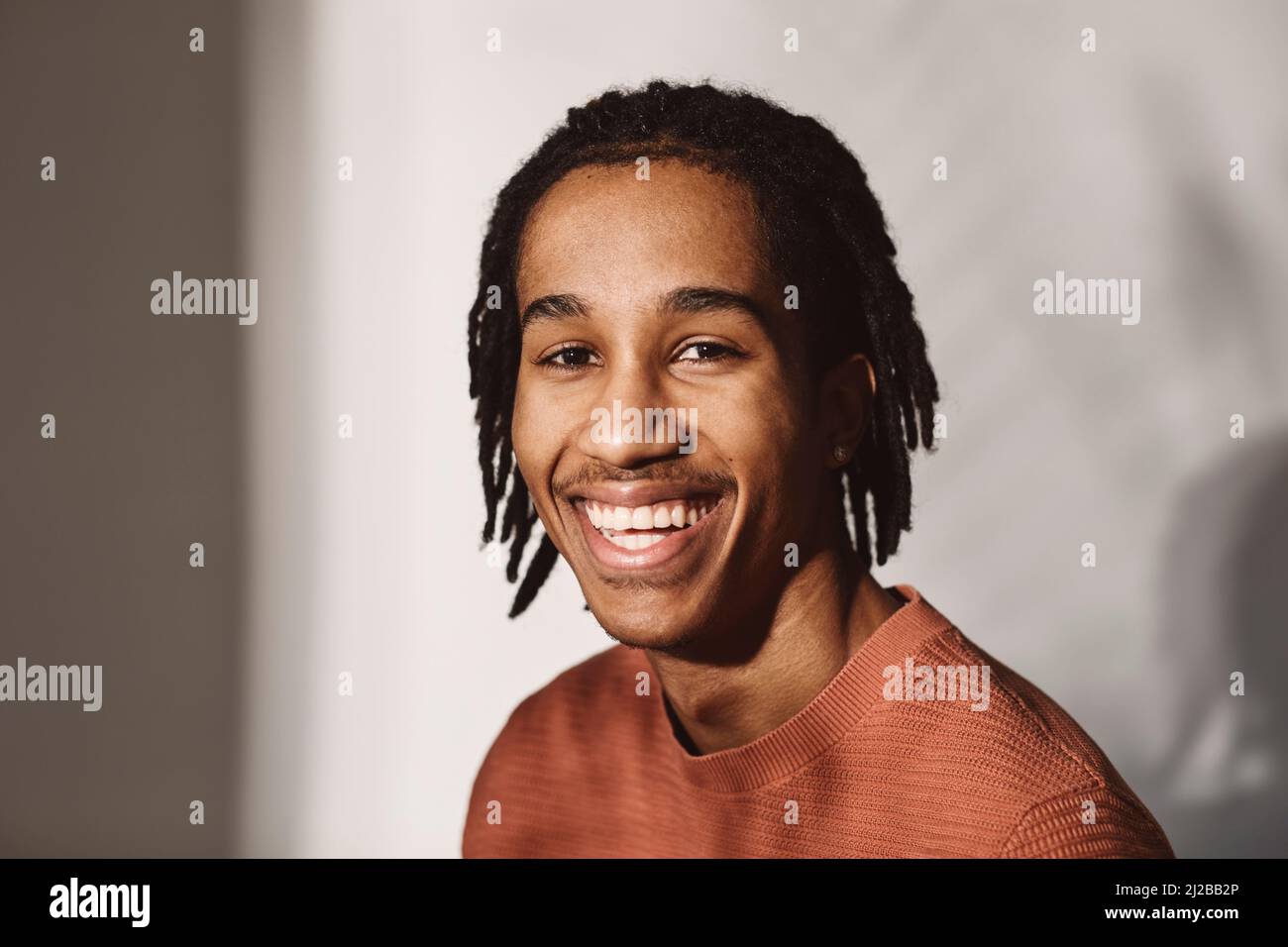 Porträt eines glücklichen jungen Mannes auf weißem Hintergrund im Studio Stockfoto